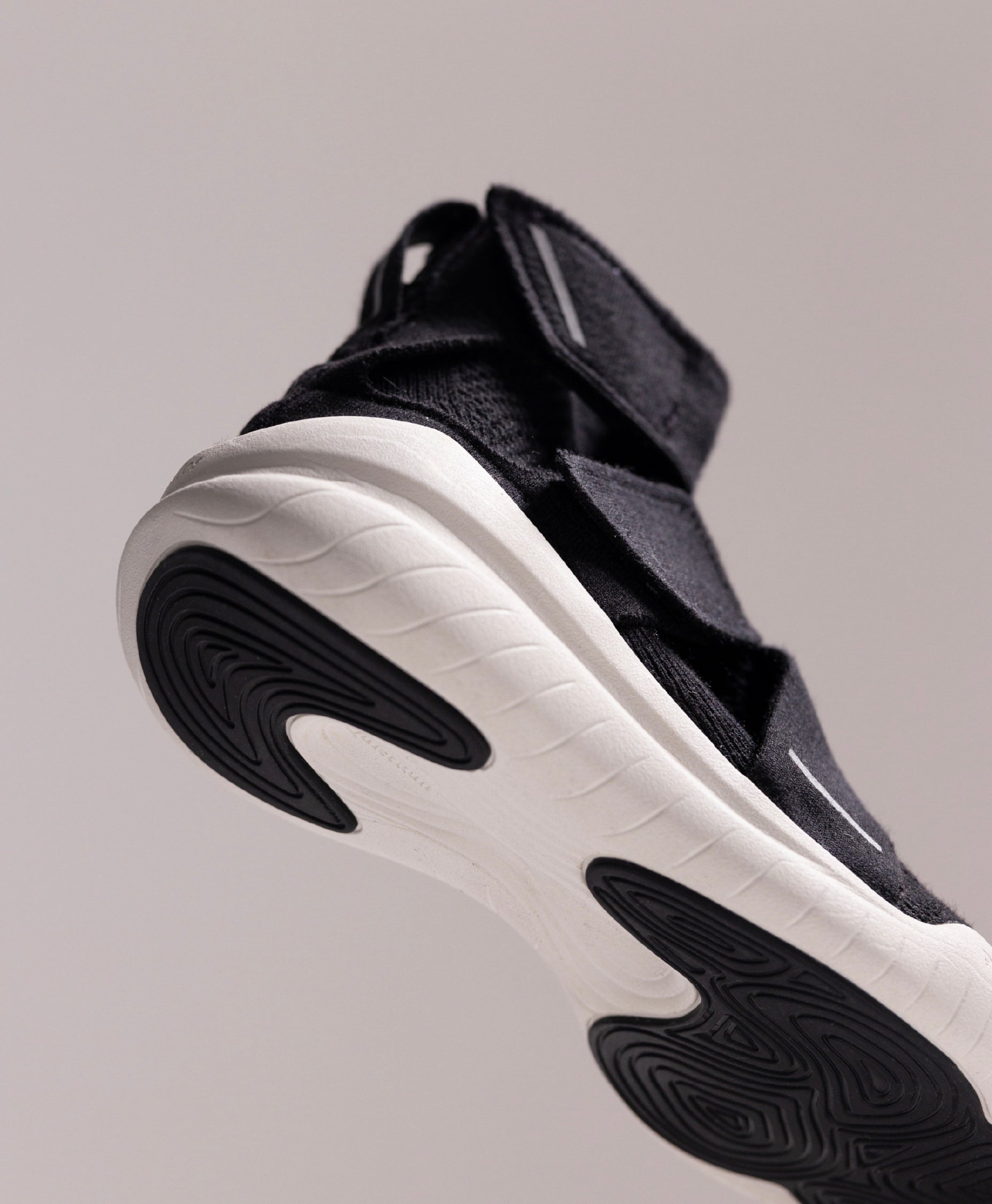 Close-up of the Philos Athena running shoes for women, in black. Featuring the QuietRun™ sole designed to reduce impact, and a laceless design with adjustable straps.