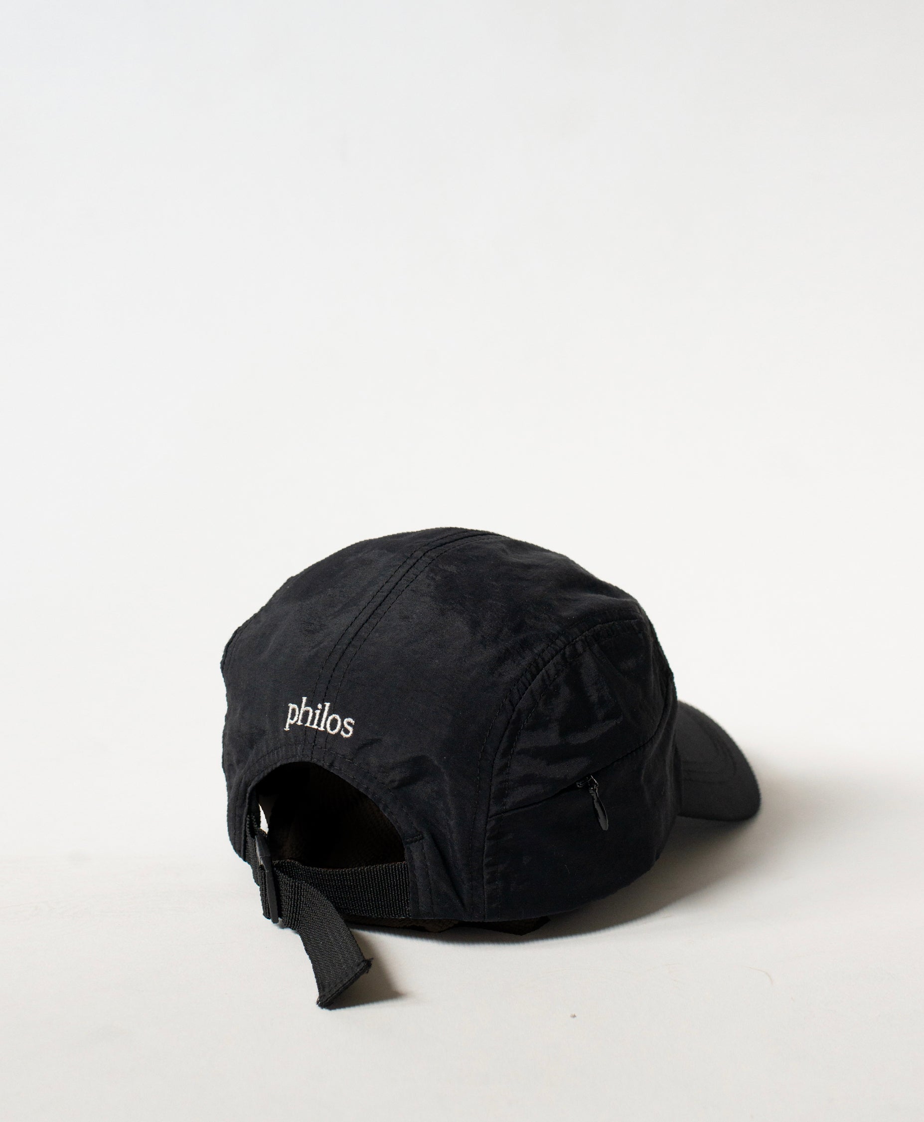 Back view of the Philos Running Cap in black, featuring an adjustable strap for a customizable fit and a discreet key pocket with a zipper.
