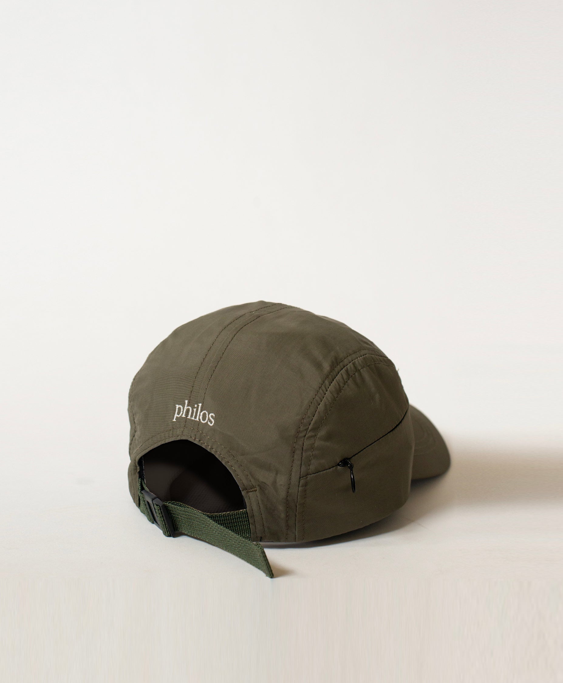 Back view of the Philos Running Cap in olive green, featuring an adjustable strap for a customizable fit and a discreet key pocket with a zipper.