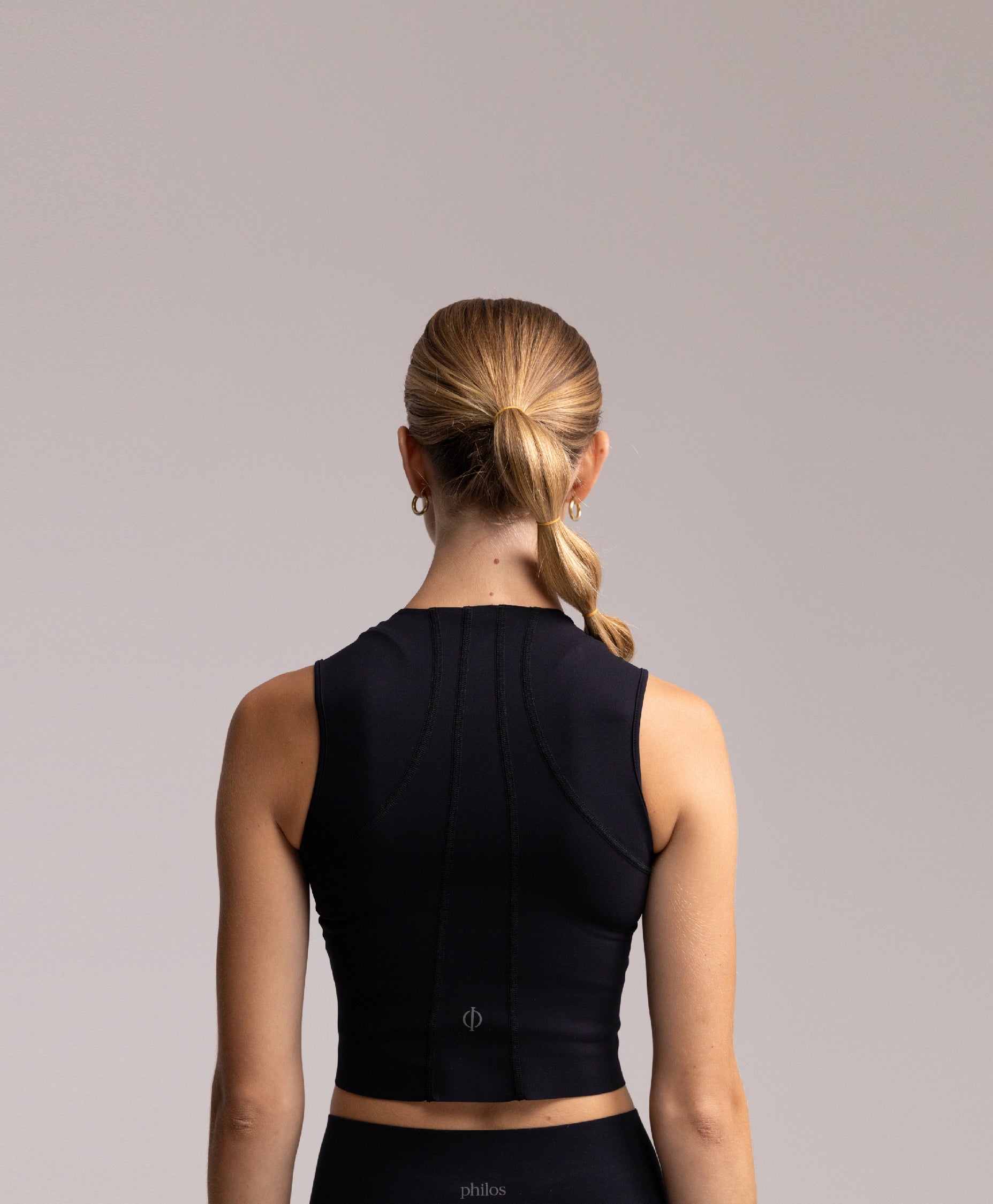 Back view of the Philos Armor Running Tank Top, highlighting anatomically inspired seams and reflective logos for added visibility.