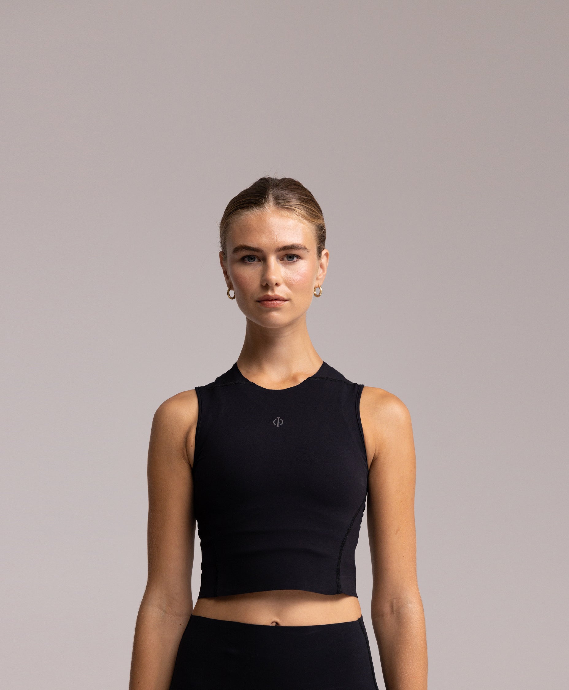 Front view of the Philos Armor Running Tank Top, featuring a form-fitting, cropped design with breathable 4-way stretch fabric for comfort.