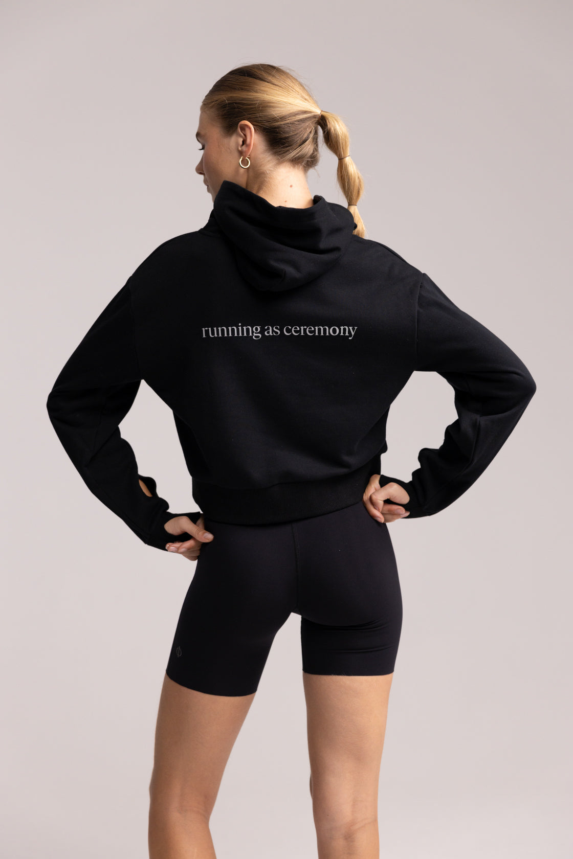 Back view of the Philos Armor Running Hoodie, highlighting the reflective logo and cropped, relaxed design for performance.