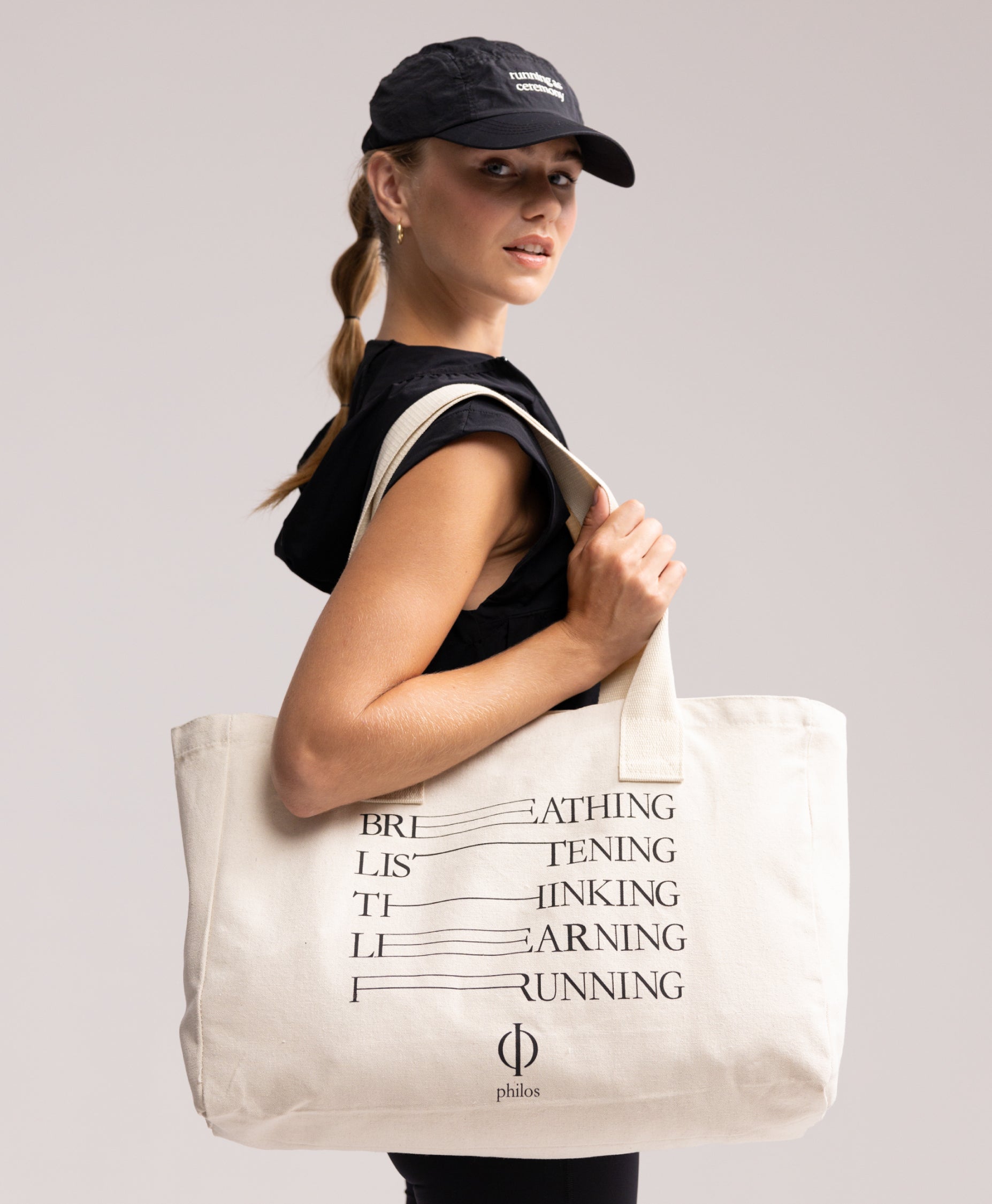 Front view of the Philos tote bag, showcasing its natural, undyed canvas material and reinforced webbing handles for strength.